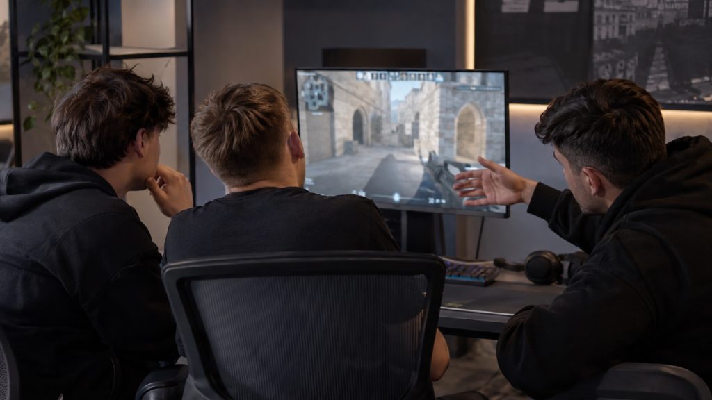 Illustrative scene of teammates discussing a tactical-shooter replay; not actual Aurora players